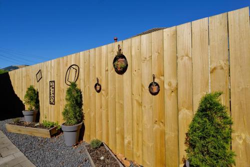 a fence with potted trees and lights on it at Mosgiel Regency Motel in Mosgiel