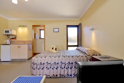 a bedroom with a dog sitting on a bed at Mosgiel Regency Motel in Mosgiel