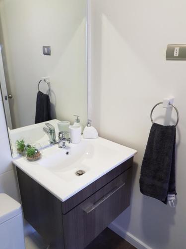 a bathroom with a sink and a mirror at Condominio Alto Hacienda - Coquimbo in Coquimbo