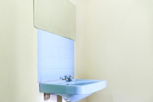 a bathroom with a blue sink and a mirror at Mertha Jati Hotel in Kuta