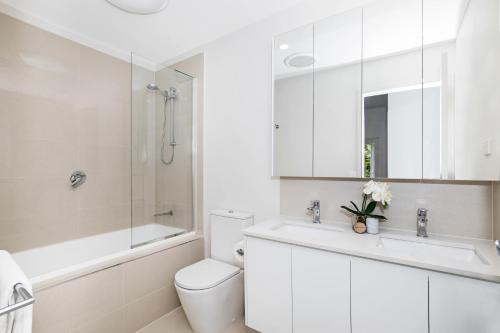 La salle de bains est pourvue d'un lavabo, de toilettes et d'une douche. dans l'établissement Park Avenue Terrace House Sleeps 9, à Brisbane