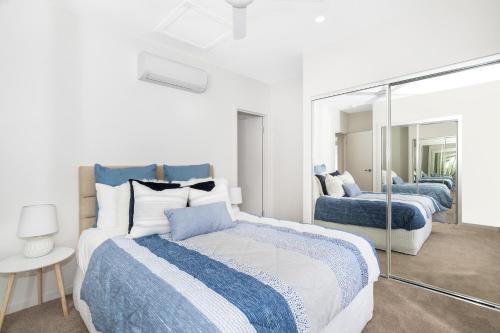a bedroom with two beds and a mirror at Park Avenue Terrace House Sleeps 9 in Brisbane