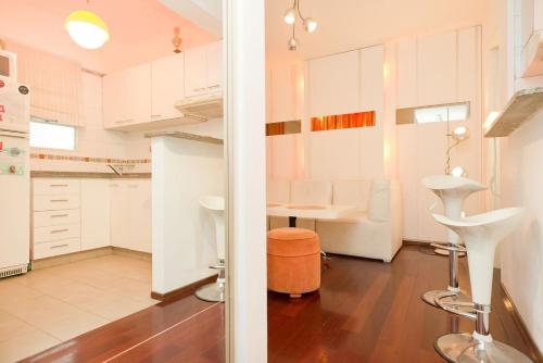 a kitchen with white cabinets and a table in it at Trendy and Cozy Studio Palermo in Buenos Aires