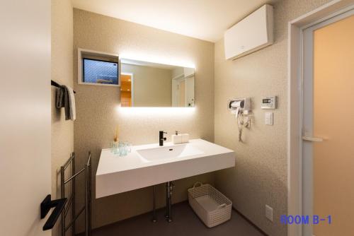 a bathroom with a white sink and a mirror at Guest Villa Hakone Yumoto RiverSide in Hakone