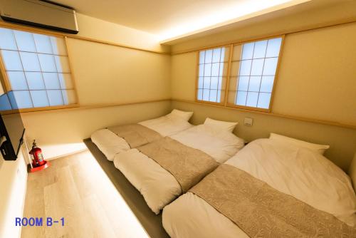 a bed in a room with three pillows at Guest Villa Hakone Yumoto RiverSide in Hakone