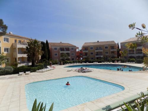 une grande piscine dans une cour avec des bâtiments dans l'établissement Appartement piscine mer montagne, aux Issambres
