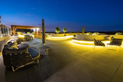 a rooftop patio with chairs and tables at night at The Sebel Melbourne Malvern in Melbourne