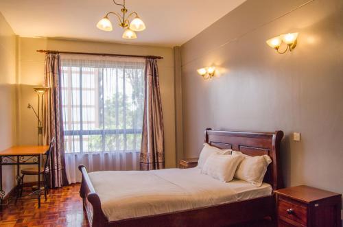 1 dormitorio con cama y ventana grande en KenGen Furnished and Serviced Apartments, en Nairobi