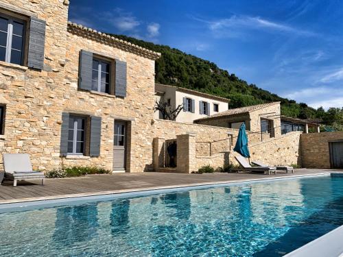 a villa with a swimming pool in front of a building at Mas des Amis in Séguret