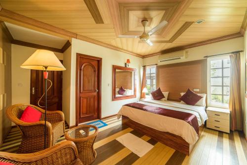 Reveries Maldives في غان: غرفة نوم بسرير وكرسي في غرفة
