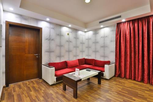 a living room with a red couch and a table at أحلى الأيام للوحدات الفندقية in Jeddah