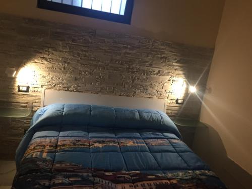 a bedroom with a bed with a stone wall at Carmine's holiday home in Torre Annunziata