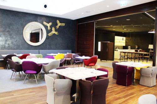 a restaurant with tables and chairs in a room at Hyatt Place Dubai Wasl District Residences in Dubai