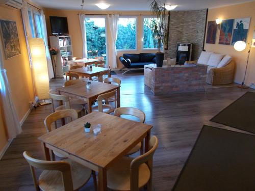 a living room with wooden tables and chairs at Quartier SansSouci Hostel in Potsdam