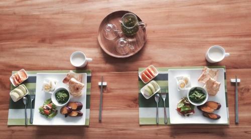 two plates of food on a wooden table at 飲山風民宿 in Jian
