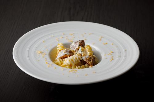 a plate of food with pasta on a table at UNWIND HOTEL & BAR OTARU in Otaru