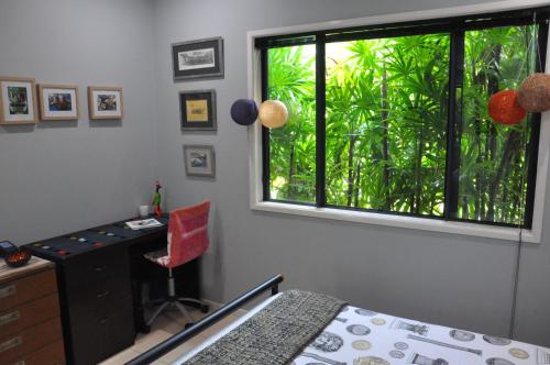 a bedroom with a window with a desk and a chair at STUNNING MAGNETIC ISLAND HOME, PRIVATE, LARGE POOL, CHILDREN AND PETS on REQUEST PLEASE in Horseshoe Bay