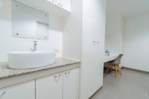 La salle de bains blanche est pourvue d'un lavabo et d'un bureau. dans l'établissement RedDoorz Plus @ Roxas Street Davao, à Davao