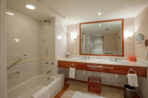 a bathroom with a tub and two sinks and a mirror at JEN Shenyang by Shangri-La in Shenyang