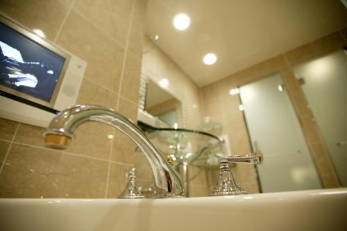 lavabo con TV y lavabo en Nonno Classic Hotel (Adult Only), en Yokkaichi