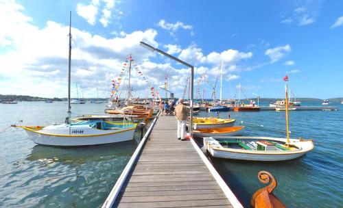 a dock with boats on the water with a man standing on it at The Brighton Apartments in Toronto