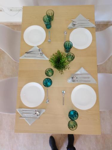 a table with white plates and a plant on it at El apartamento de Marina en Chilches playa in Xilxes