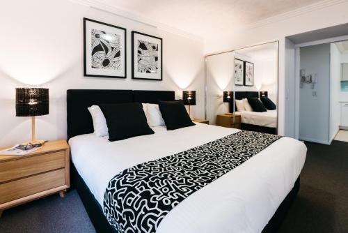 a bedroom with a large bed with a black and white blanket at Gabba Central Apartments in Brisbane