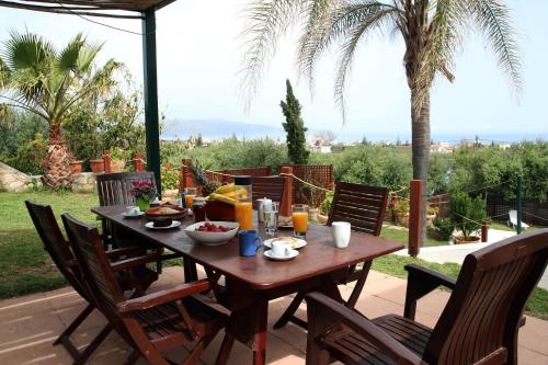 una mesa de madera con comida en la parte superior de un patio en Villa Palma, en Máleme