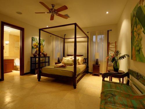 a bedroom with a canopy bed and a fan at Villa Koa - Hale Koa LUXURY Beachfront in Laie