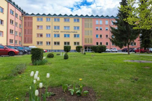 a building with flowers in the grass in front of it at Hotel Schloss Nebra in Nebra