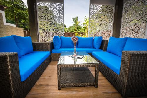 a patio with blue couches and a table at The Pearl Luxury Pool Villas in Ko Chang