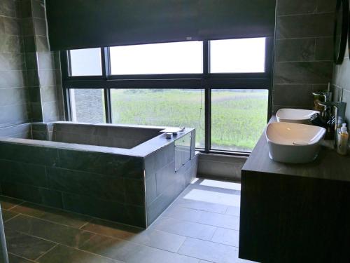 a bathroom with a large tub and a sink at 沐日海邊民宿 in Magong