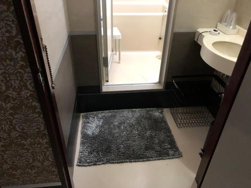 a bathroom with a shower and a sink and a mirror at Business Stay in Satsumasendai
