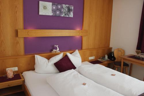 1 dormitorio con 2 camas y pared púrpura en Haus Astoria, en Sankt Leonhard im Pitztal