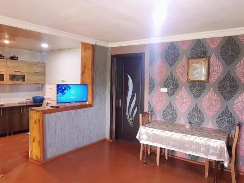 una sala da pranzo con tavolo e TV a parete di wine valley a Udabno