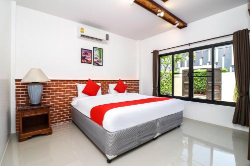 a bedroom with a bed and a window at Baan Noppadol Hua Hin Loft in Hua Hin