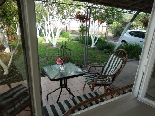 a table and chairs on a patio with a view of a yard at Apartman Zorana in Bar