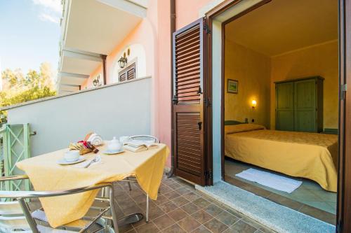 a bedroom with a bed and a table and chairs at Appartamento Gli Ontani in Cala Liberotto