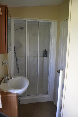 a bathroom with a shower and a white sink at Caravan 6 Berth North Shore Holiday Centre with 5G Wifi in Winthorpe