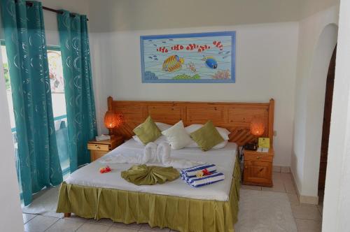 A bed or beds in a room at Coco D'or Hotel Seychelles