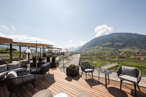patio z krzesłami i widokiem na góry w obiekcie Hotel Wessobrunn w Meranie