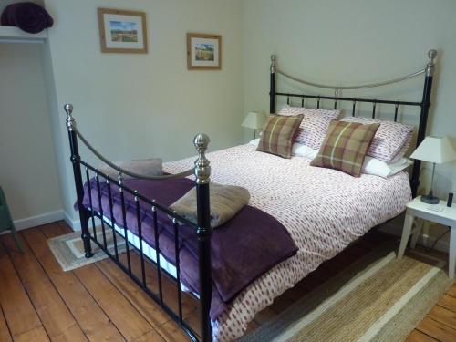 um quarto com uma cama preta com almofadas em No 10 Dulas em Hay-on-Wye