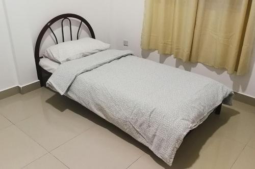 En eller flere senge i et værelse på HomezStay Airport Miri