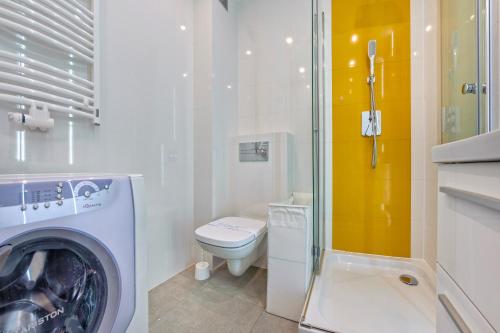 a bathroom with a washing machine and a toilet at Bursztynowe Osiedle Jantar, Sun & Snow in Jantar