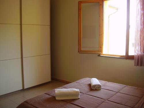 a bedroom with a bed with two towels on it at Appartamenti Easy Time in Rio Marina