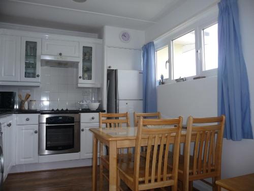 a kitchen with a table and chairs and a refrigerator at 151 Perran Sands in Perranporth