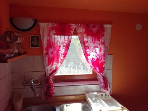 ventana de cocina con cortinas rosas y lavamanos en Epicentar, house for rent, sobe - Ivanec, en Ivanec