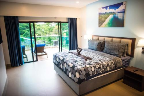 a bedroom with a large bed and a balcony at The Pearl Luxury Pool Villas in Ko Chang