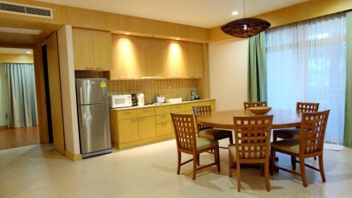 a kitchen with a table and chairs and a refrigerator at Hua Hin Blue Lagoon in Cha Am