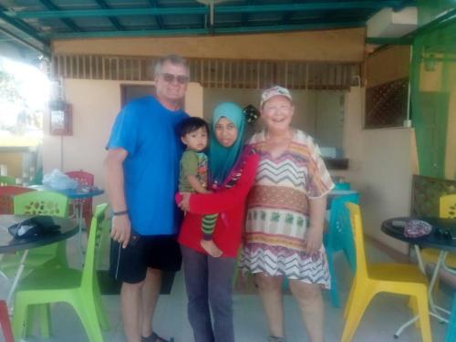 a man and a woman and a child posing for a picture at Tokman Inn in Pantai Cenang